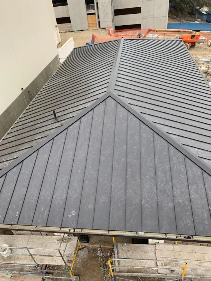 Commercial metal roof construction with crane equipment in Elsmere